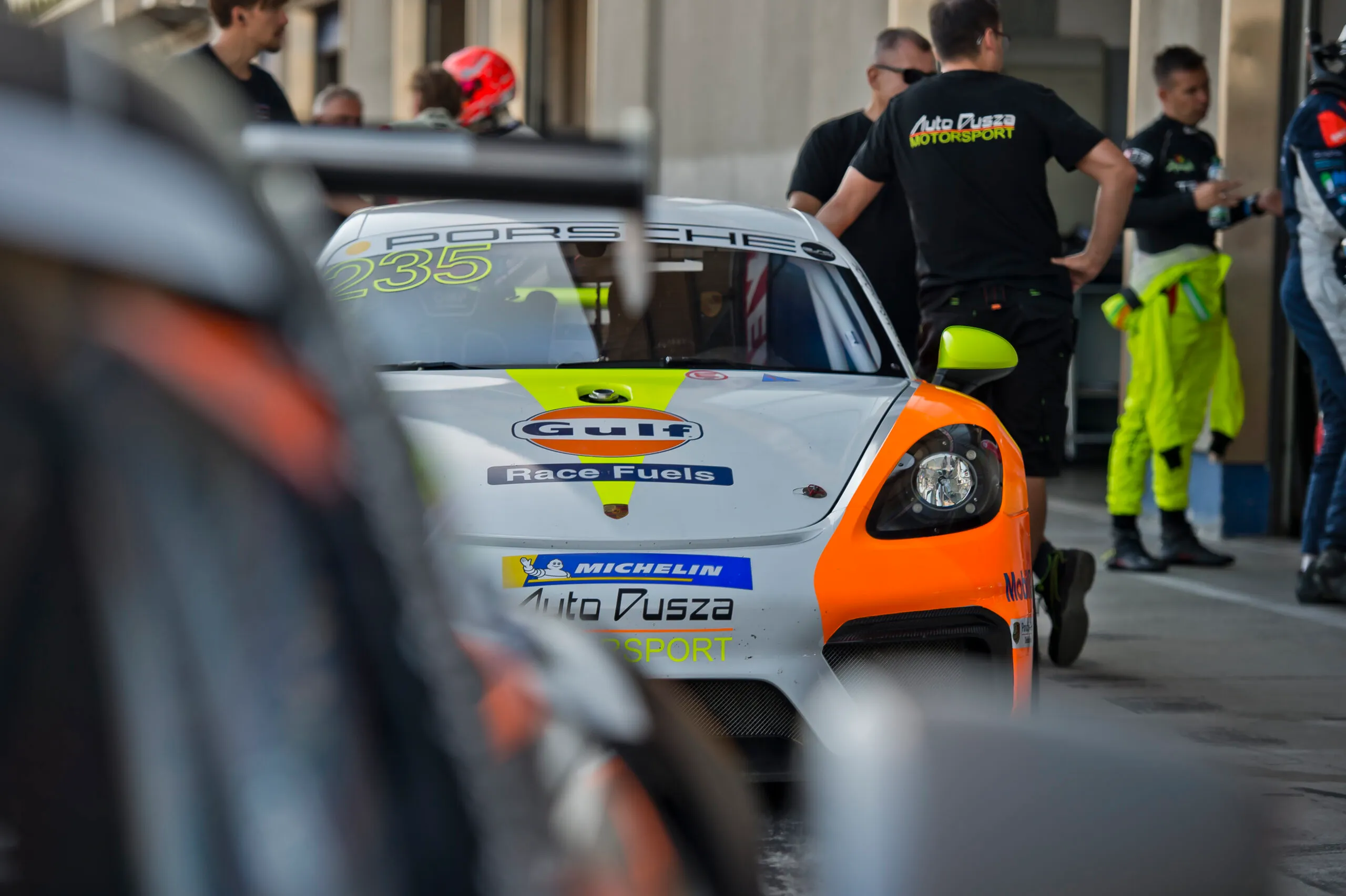 Mechanicy Auto Dusza Motorsport przy wyścigowym Porsche w parku maszyn