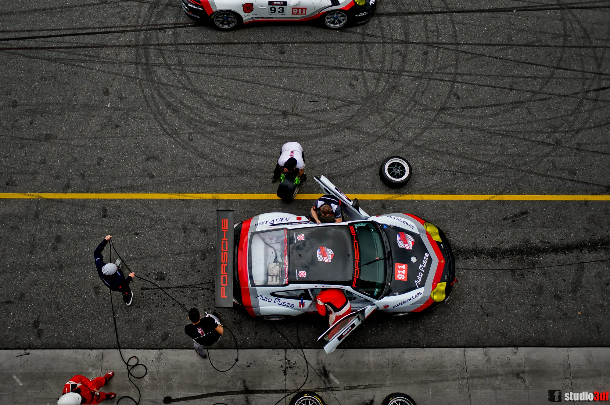 Pit stop widziany z góry — obsługa wyścigowego Porsche w alei serwisowej