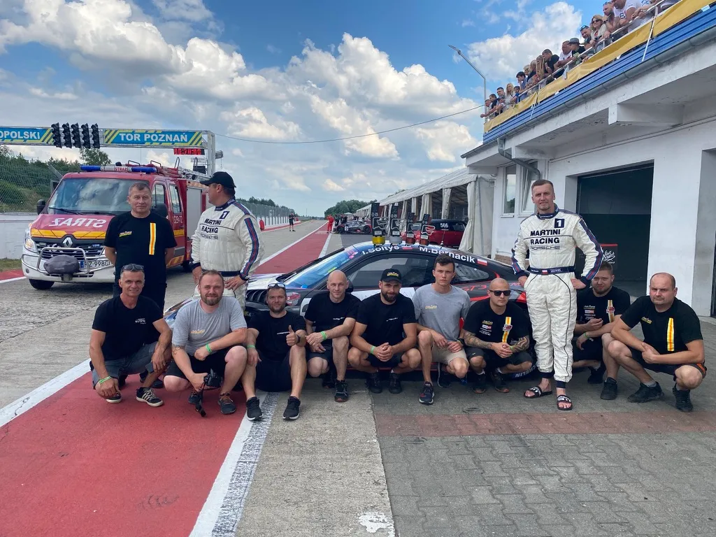 Zespół Auto Dusza Motorsport przy wyścigowym Porsche w alei serwisowej